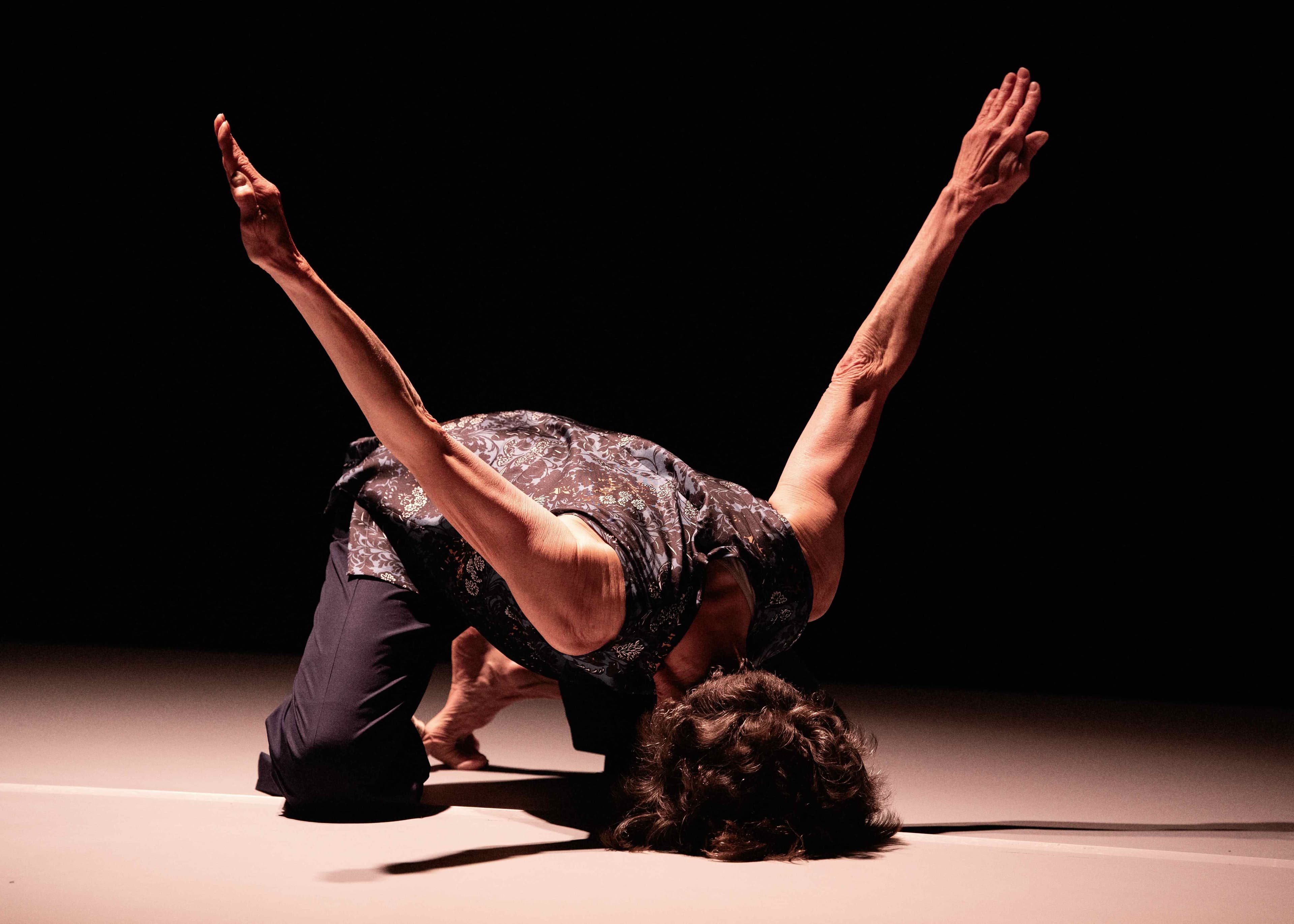 Lauren kneels down with her head on the floor and her arms in the air