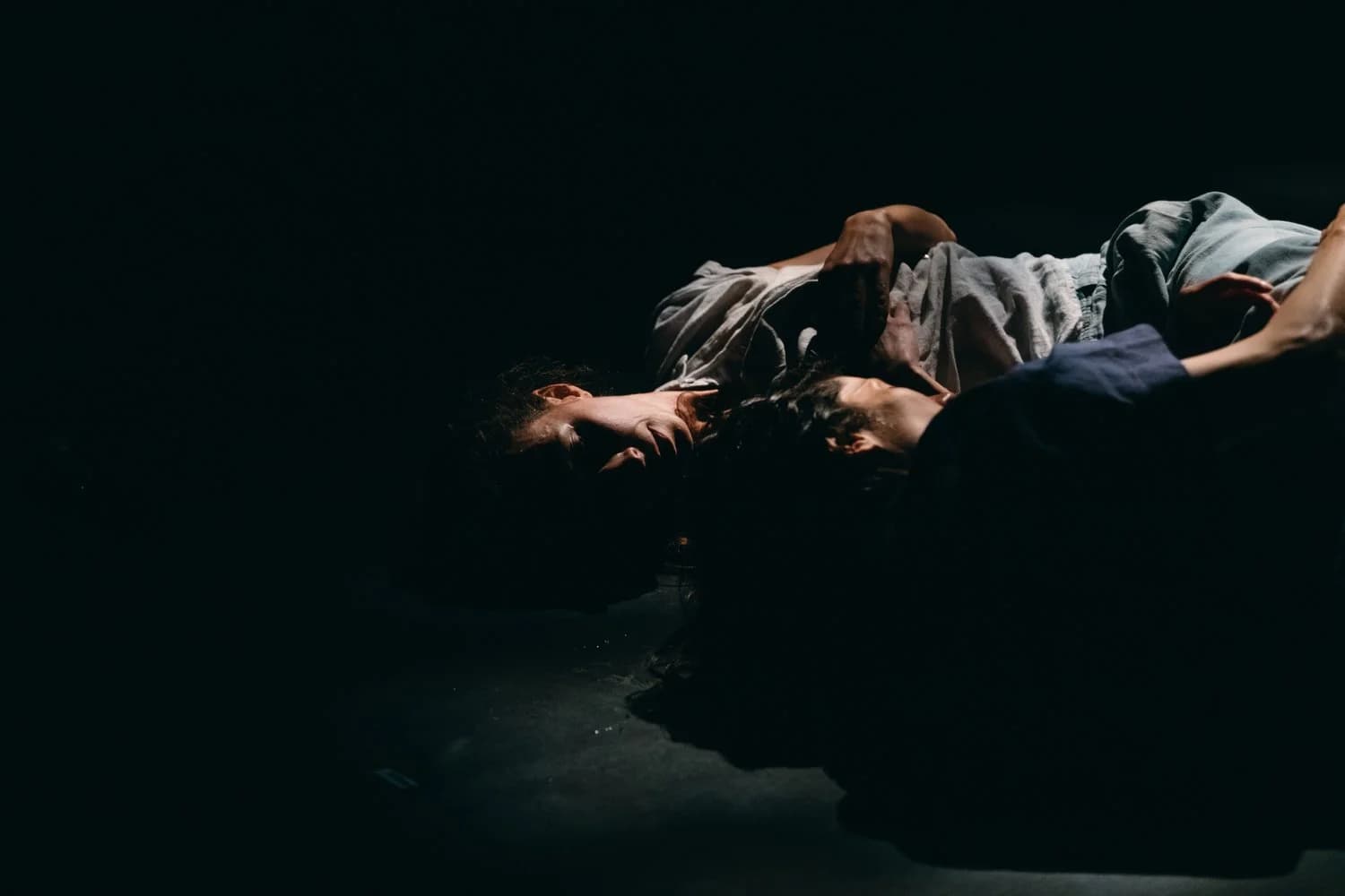 Petra and Louise lying on the floor cuddling gently